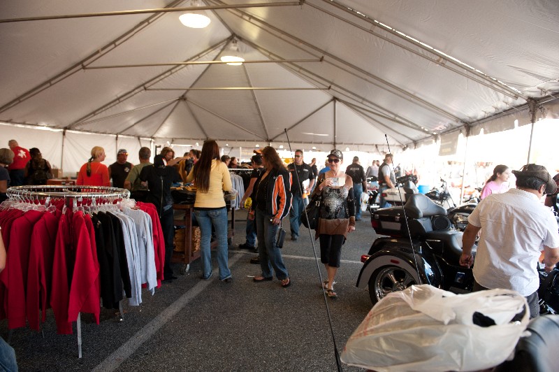 event attendees checking out vendor apparel under large tent