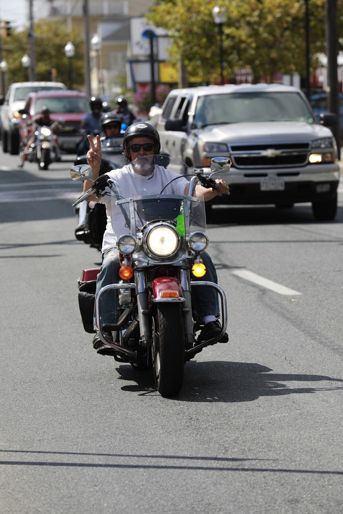 motorcylist flashing peace sign while driving on road